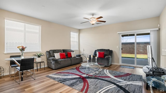 living room with ceiling fan, light hardwood / wood-style floors, and a healthy amount of sunlight