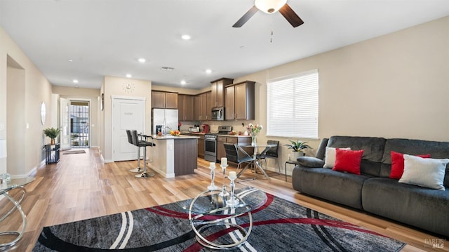 living room featuring ceiling fan and light wood-type flooring