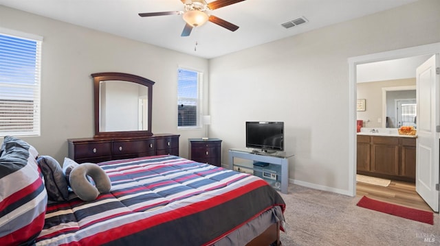 carpeted bedroom with ceiling fan and ensuite bathroom