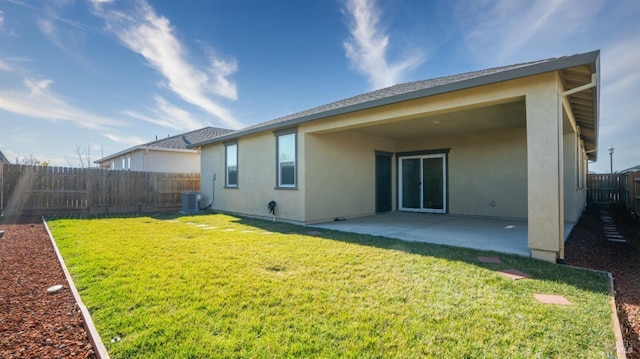 rear view of house with a patio area, a yard, and central AC