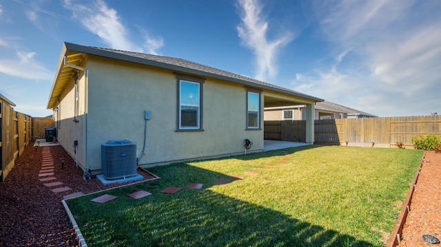 back of house featuring central air condition unit and a yard