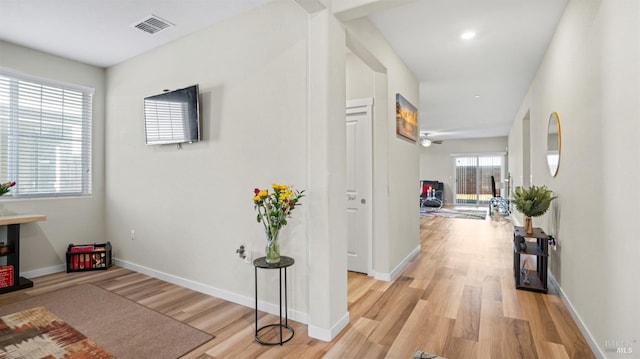 corridor with a healthy amount of sunlight and light hardwood / wood-style floors