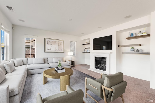 carpeted living room featuring built in shelves