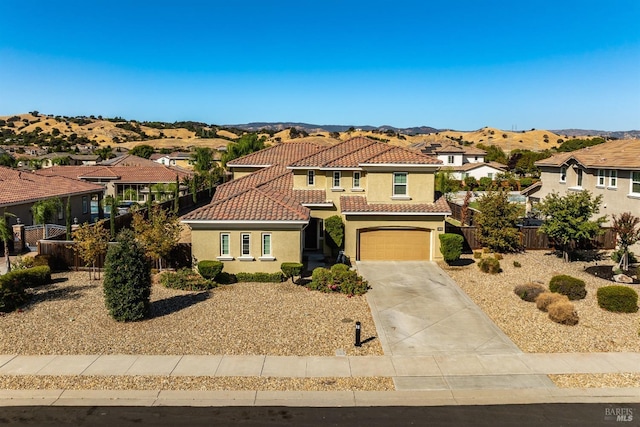 mediterranean / spanish-style home with a mountain view and a garage