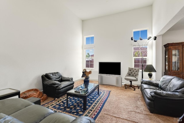 living room featuring a high ceiling, carpet floors, and plenty of natural light