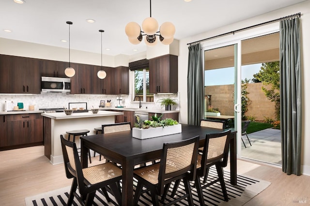 dining area with a chandelier, light hardwood / wood-style flooring, and sink