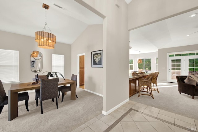 tiled dining space featuring vaulted ceiling and an inviting chandelier