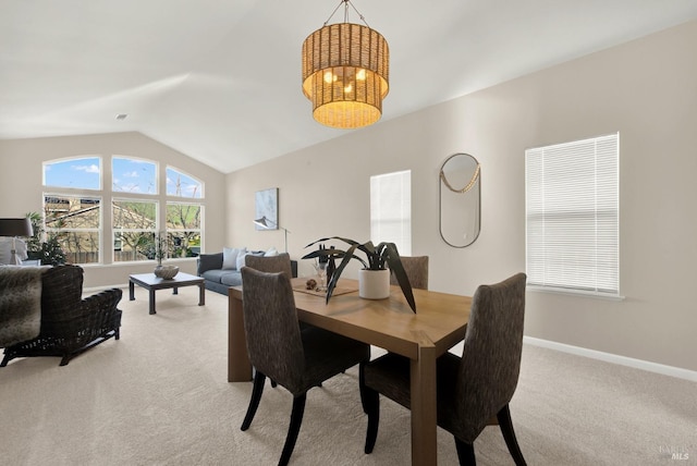 dining area featuring light colored carpet and lofted ceiling