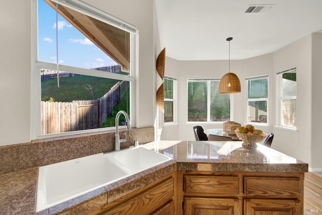 kitchen with black fridge, kitchen peninsula, decorative light fixtures, a breakfast bar area, and light carpet