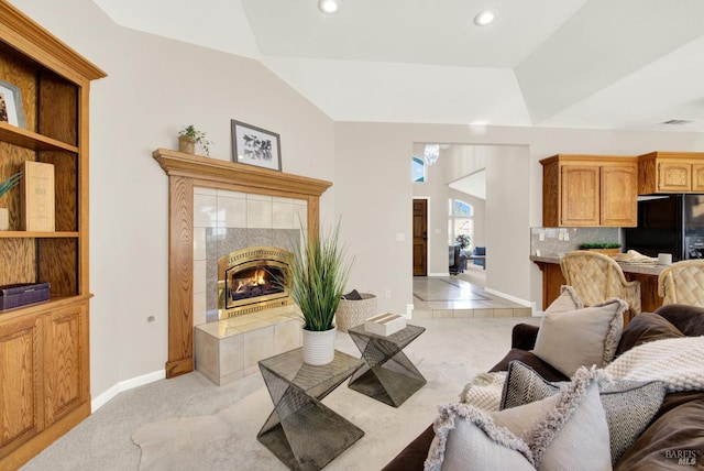 carpeted living room with a tile fireplace and lofted ceiling