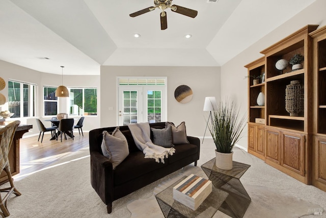 carpeted living room with ceiling fan, french doors, and vaulted ceiling