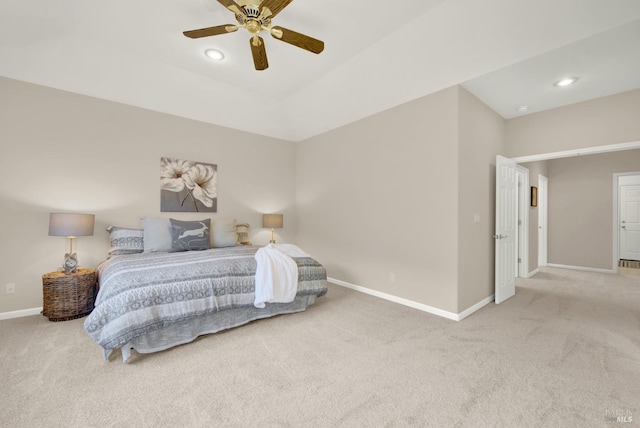 carpeted bedroom with ceiling fan and a tray ceiling