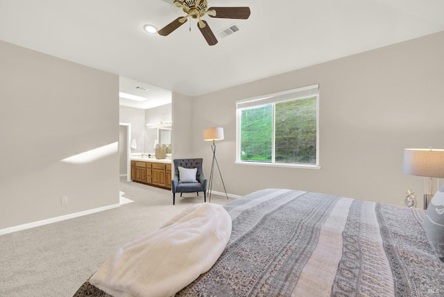 bedroom with light carpet, ensuite bathroom, and ceiling fan