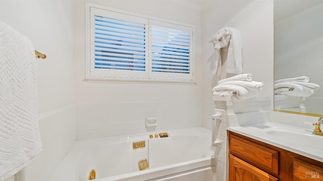 bathroom with a bathtub, vanity, and ornamental molding