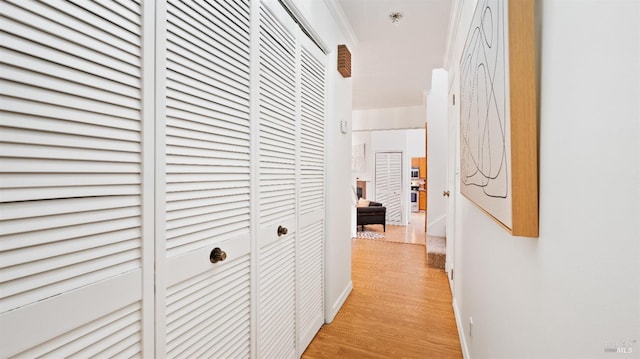 hall featuring light wood-type flooring and ornamental molding