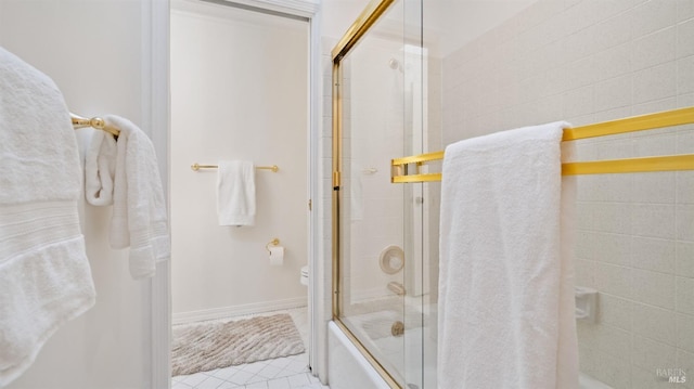 bathroom featuring tile patterned floors, toilet, and bath / shower combo with glass door