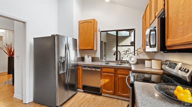 kitchen featuring sink, light wood-type flooring, and appliances with stainless steel finishes