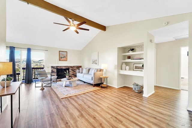 living room featuring lofted ceiling with beams, built in shelves, ceiling fan, light wood-type flooring, and a fireplace