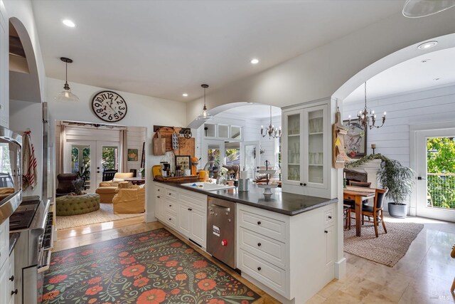 dining area with wood walls, crown molding, and an inviting chandelier