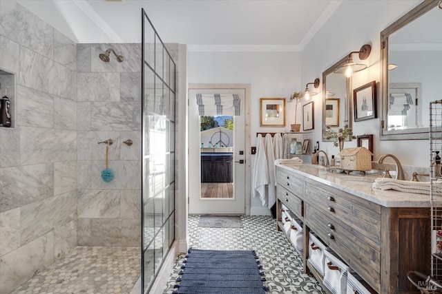 bathroom featuring a tile shower, vanity, and ornamental molding