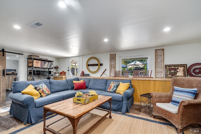 living area featuring recessed lighting, visible vents, and a barn door