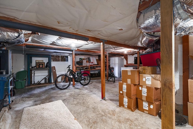 unfinished basement featuring freestanding refrigerator