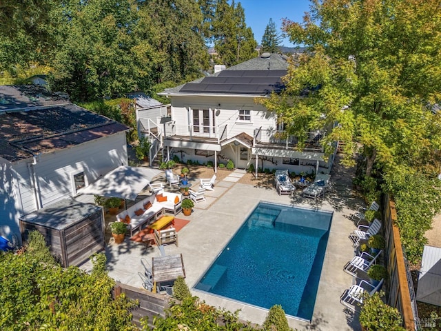 outdoor pool featuring a patio area, a fenced backyard, and stairs