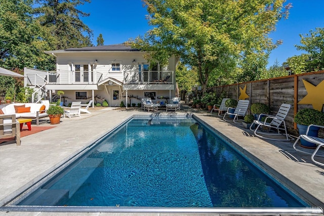 pool featuring an outdoor living space, a fenced backyard, a patio, and stairway