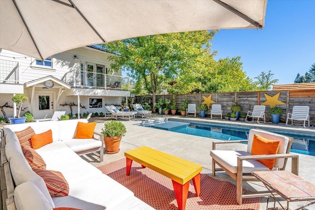 view of pool featuring a patio, outdoor lounge area, fence, and a fenced in pool