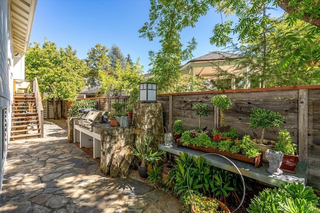 view of patio featuring exterior kitchen, fence private yard, area for grilling, and stairs