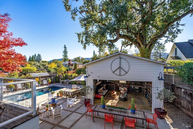 exterior space with a fenced in pool, a fenced backyard, an outbuilding, a storage structure, and a patio area