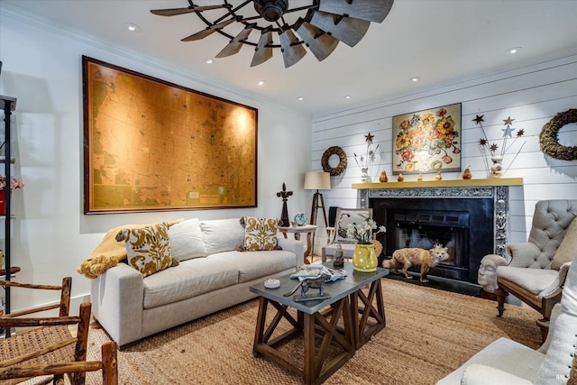 living room featuring ceiling fan, crown molding, and wood walls