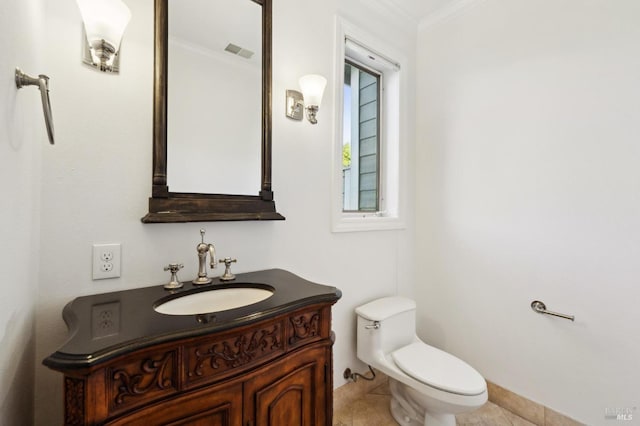 bathroom with tile patterned floors, crown molding, vanity, and toilet