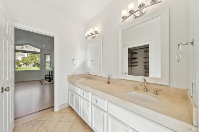 full bathroom with lofted ceiling, double vanity, a sink, and tile patterned floors