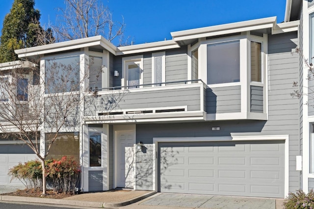 view of property featuring a garage and a balcony