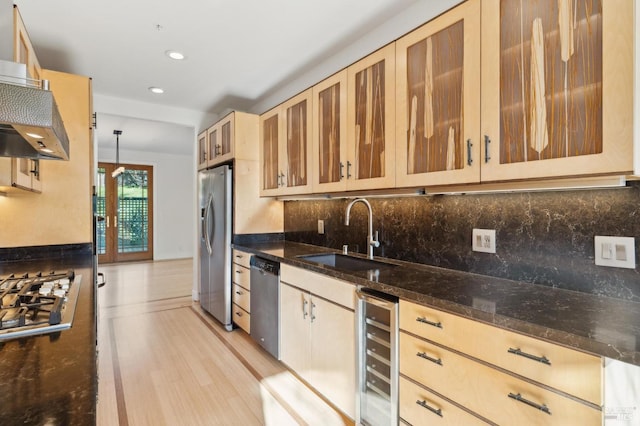 kitchen with beverage cooler, glass insert cabinets, appliances with stainless steel finishes, decorative light fixtures, and a sink