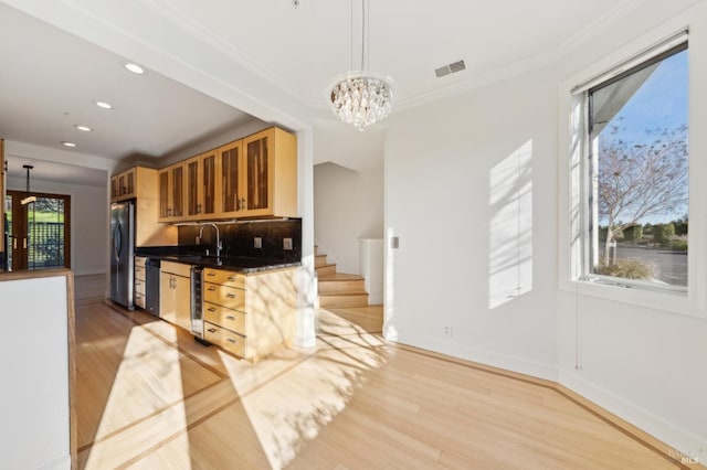 kitchen with pendant lighting, plenty of natural light, sink, and stainless steel appliances