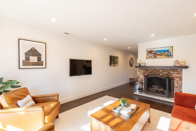 living room with a fireplace and dark wood-type flooring