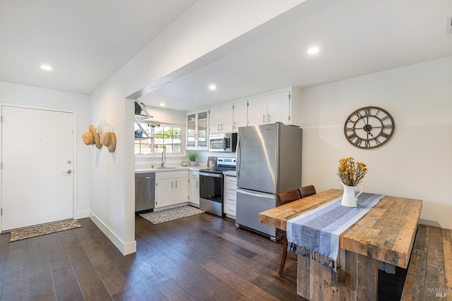 kitchen with dark hardwood / wood-style flooring, sink, white cabinets, and stainless steel appliances