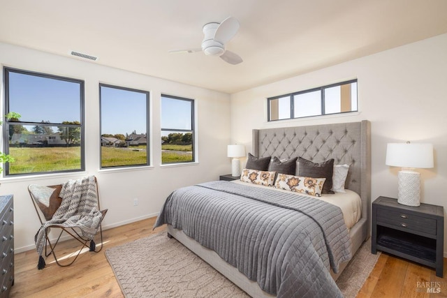 bedroom with visible vents, light wood-style flooring, ceiling fan, and baseboards