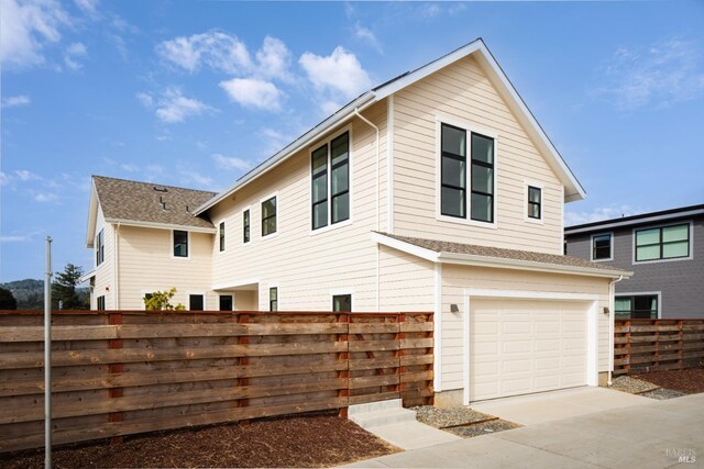 exterior space with fence, driveway, and a garage