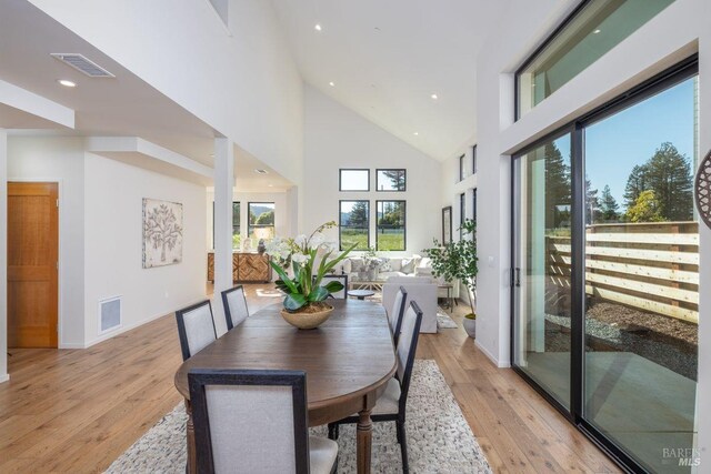 dining room featuring recessed lighting, high vaulted ceiling, visible vents, and light wood-style floors