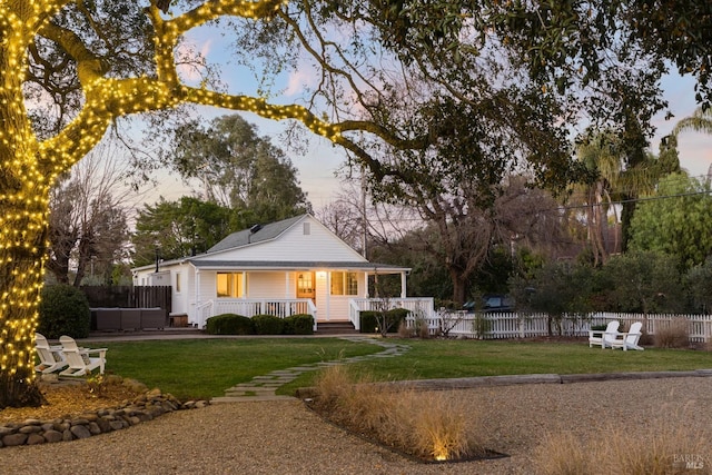 farmhouse inspired home with covered porch and a yard