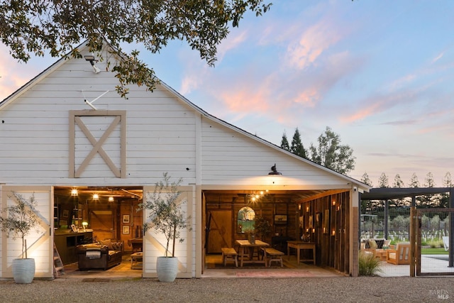 back house at dusk featuring an outbuilding