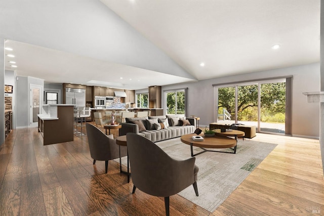 living room with high vaulted ceiling and light hardwood / wood-style floors