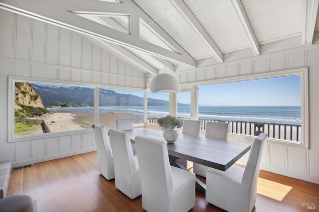 sunroom / solarium with vaulted ceiling with beams, a water view, and a wealth of natural light