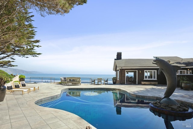 view of swimming pool featuring a water view and a patio