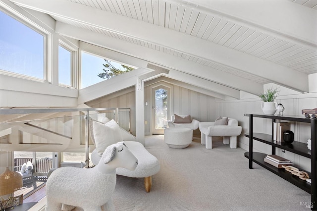 sitting room featuring carpet flooring and vaulted ceiling with beams