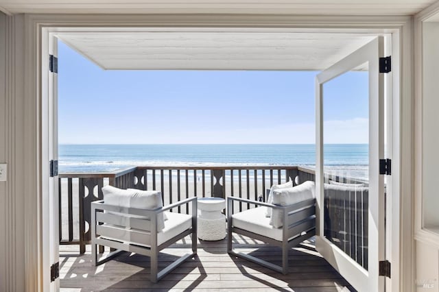 balcony with a water view and a view of the beach