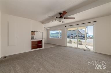 unfurnished living room with carpet, ceiling fan, and a healthy amount of sunlight